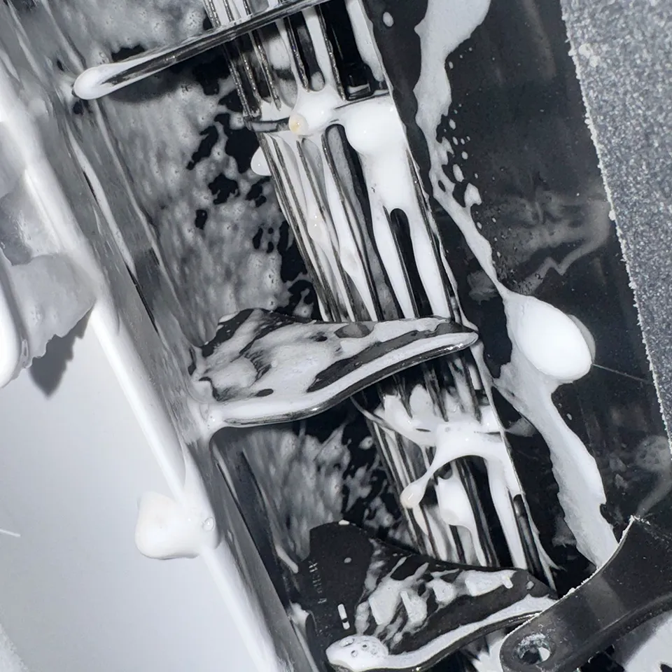 ilmalämpöpumpun huoltopesu käynnissä: puhdistusaine lamelleissa