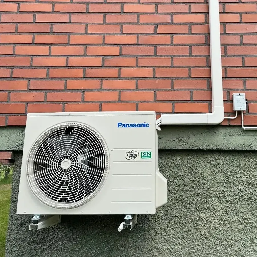 Panasonic ilmalämpöpumpun ulkoyksikkö asennettuna tiilitalon sokkeliin