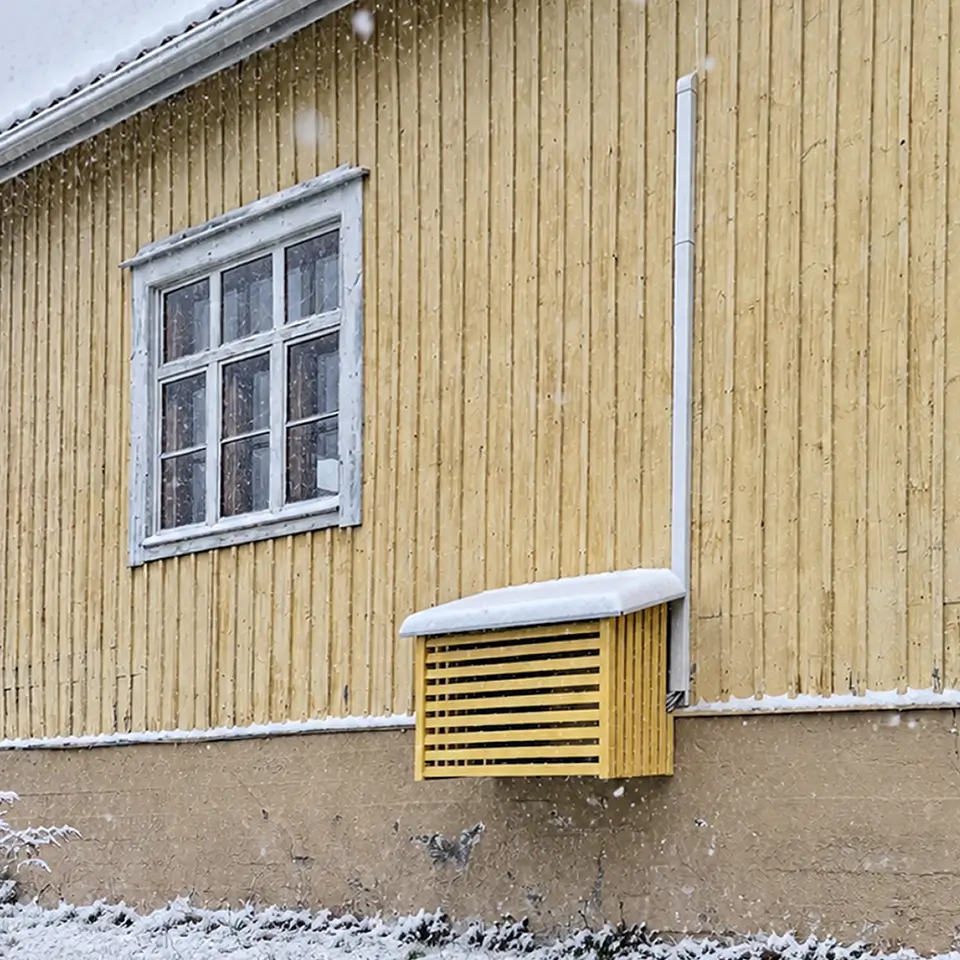 Vaaleankeltainen suojakotelo talvella lumisateessa